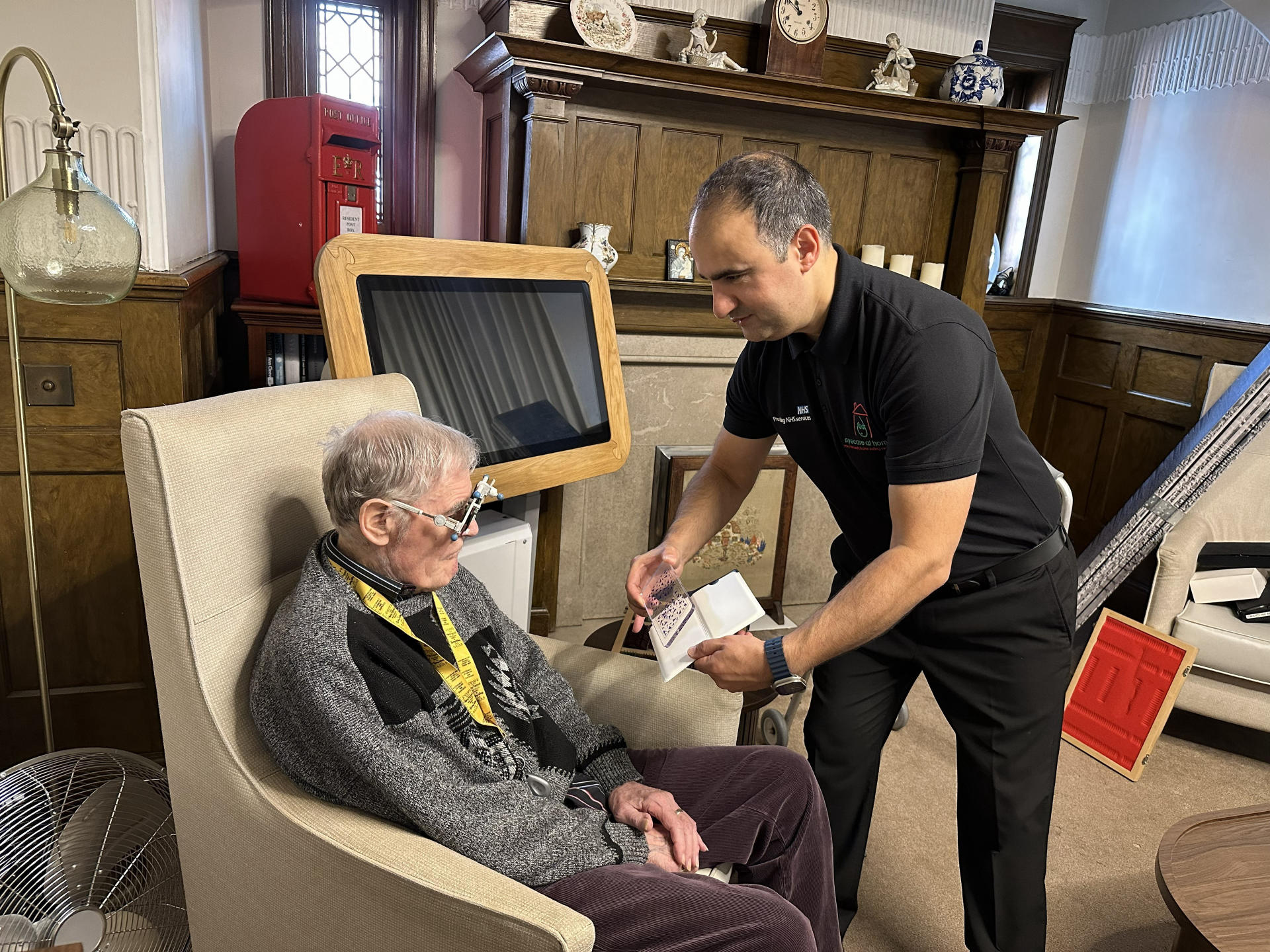 Mohammed Mir, GOC Registered Optometrist, conducting a home eye test with an elderly patient